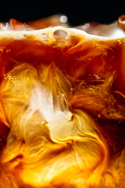 Cream being poured Into iced coffee.