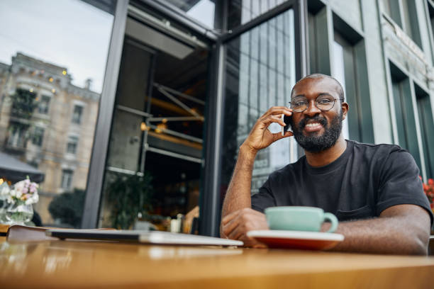 istock Mirthful man talking on the phone near the modern building 1276656355
