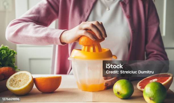 Manual Squeezing Procedure And Making Fruit Juice At Home Out Of Orange Stock Photo - Download Image Now
