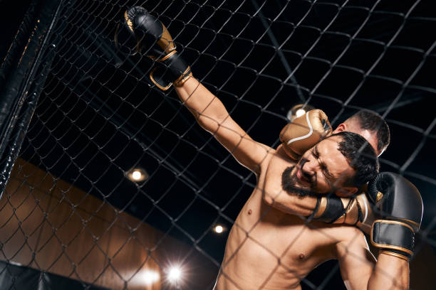 istock Struggling fighter in a clutch holding to the net 1276661474