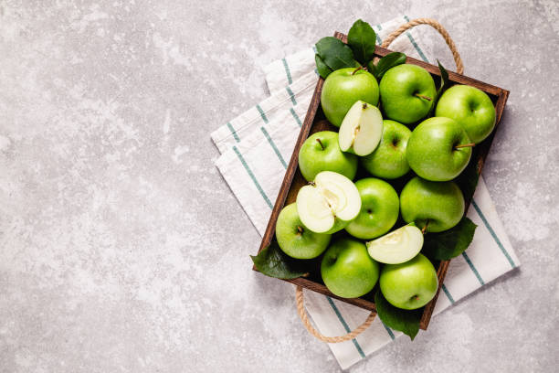istock Ripe green apples in wooden box. 1276664655