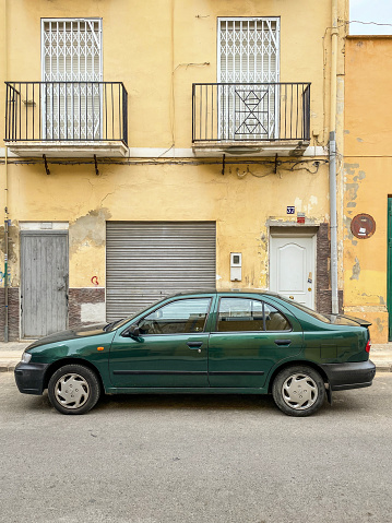 Valencia, Spain - September 24, 2020: A green Nissan car model Almera parked in the street. It is produced by the japanese manufacturer from 1995 onwards