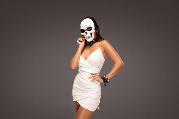 Halloween girl wearing skull mask and mini dress.