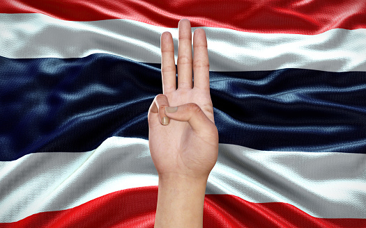 3d Illustration of a hand showing 3 fingers, a political symbol, on Thai flag background, as an act of resistance against Military Government in Thailand. Thailand political situation.