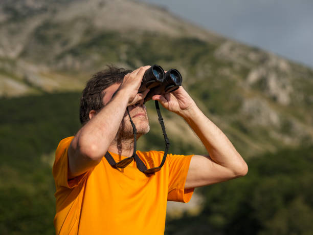istock Hiker with binoculars observes birds in the mountains 1276668575