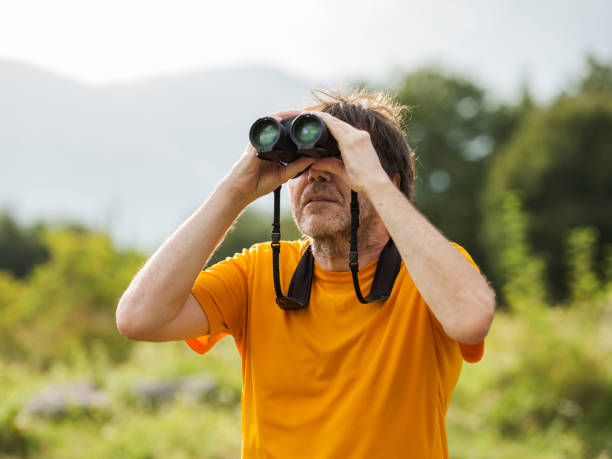 istock Hiker with binoculars observes birds in the mountains 1276668635