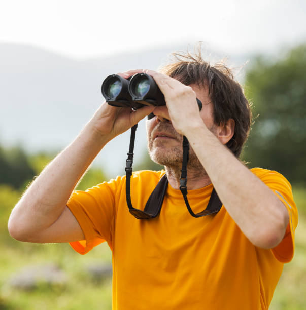 istock Hiker with binoculars observes birds in the mountains 1276668668