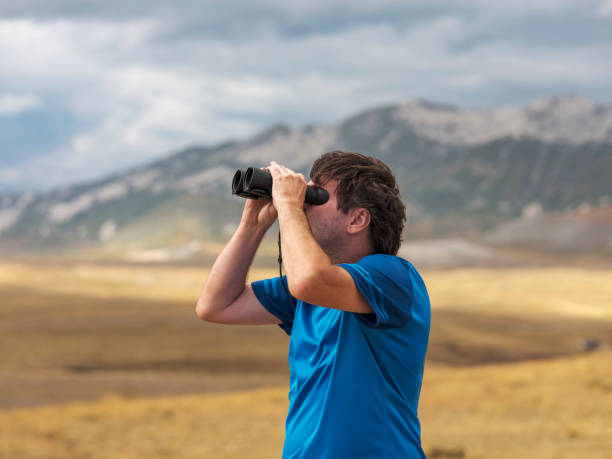 istock Hiker with binoculars observes birds in the mountains 1276668672