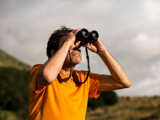 istock Hiker with binoculars observes birds in the mountains 1276668682