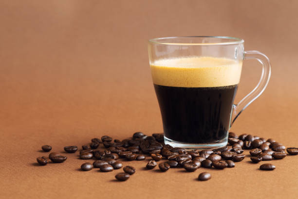 istock Cup with espresso coffee on brown background with coffee beans 1276671747