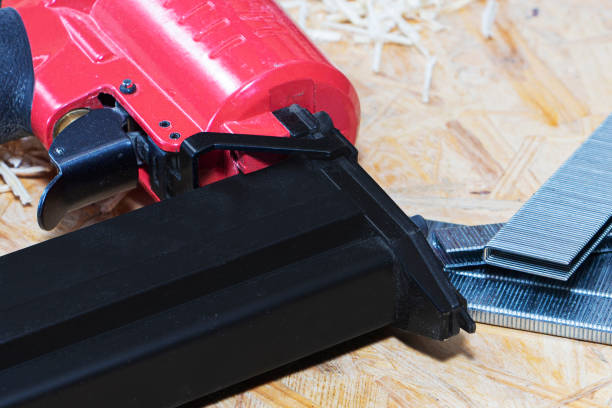 istock Red pneumatic construction stapler and a stack of staples for the stapler. 1276672831
