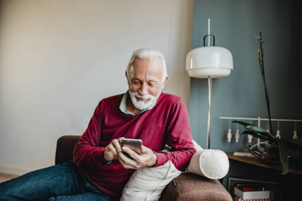 istock Senior man relaxing at home and using mobile phone 1276678370