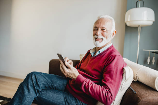 istock Senior man relaxing at home and using smart phone 1276678396