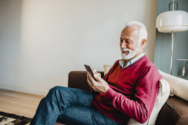 istock Senior man relaxing at home and using smart phone 1276678418