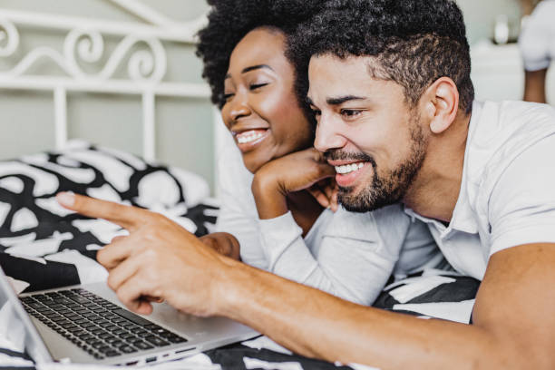 istock Young couple is using laptop in bed 1276684179
