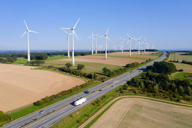Wind Turbine Farm Near The Highway Renewable energy plant - wind turbine farm near the highway, aerial view. autobahn stock pictures, royalty-free photos & images
