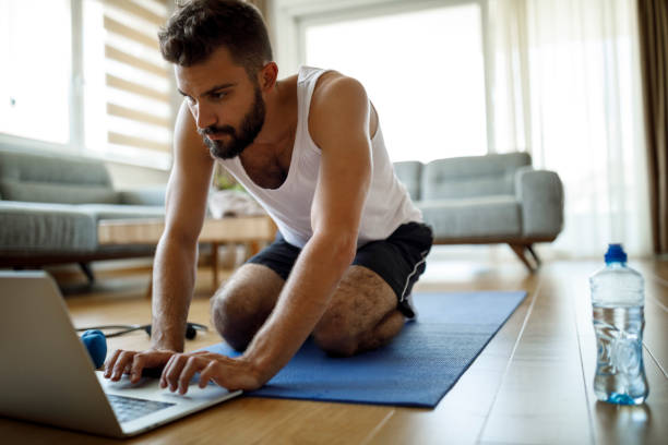 istock Young man searching online exercise classes at home 1276685954