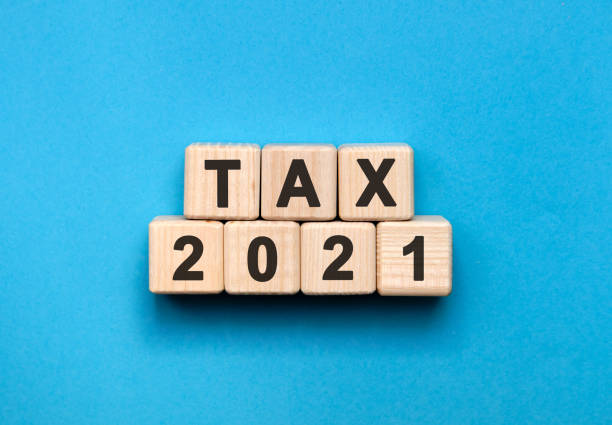 istock TAX 2021 - text concept on wooden cubes with gradient blue background 1276686020