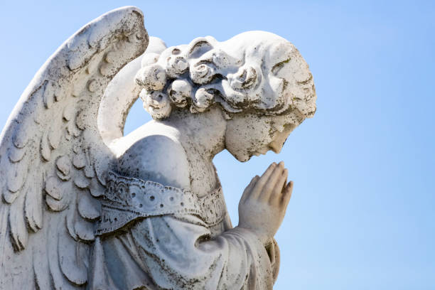 istock Angel, old statue of praying angle, blue sky background with copy space 1276686217