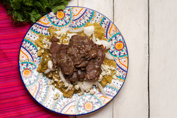 istock Mexican green chilaquiles with cecina beef steak on white background 1276687020