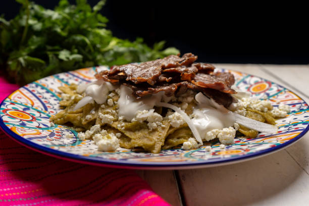 istock Mexican green chilaquiles with cecina beef steak on white background 1276687141