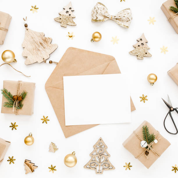 istock Styled desk with envelope, blank card, craft boxes and Christmas decorations. Flat lay. Mockup template. View from above 1276687144