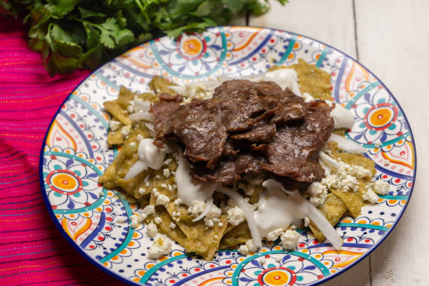 istock Mexican green chilaquiles with cecina beef steak on white background 1276687235