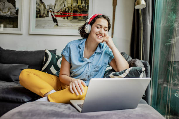 istock Young woman using laptop at home 1276689249
