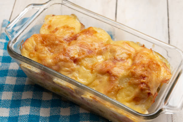 istock Scalloped potatoes with ham and cheese on white background 1276691413