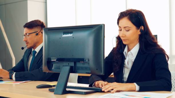 istock Business people wearing headset working in office 1276694112