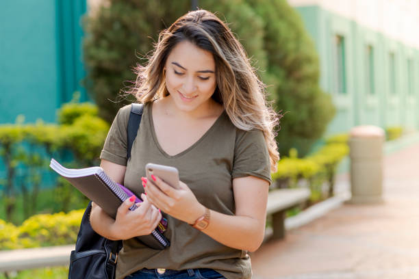 istock College girl checking notifications on her cell phone 1276694178