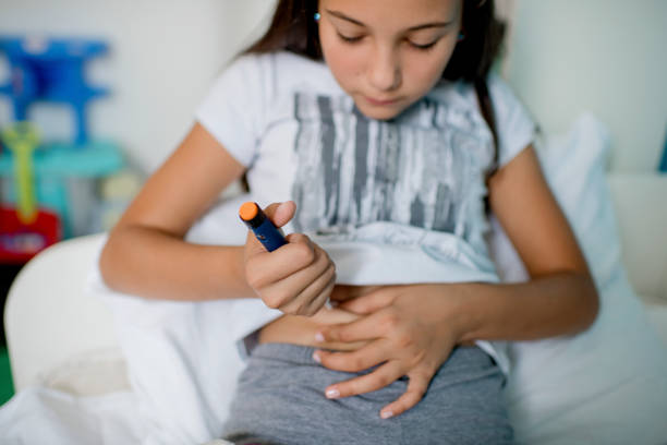 Diabetic girl injecting insulin in hers stomach stock photo