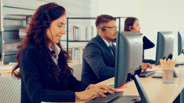 istock Business people wearing headset working in office 1276700411