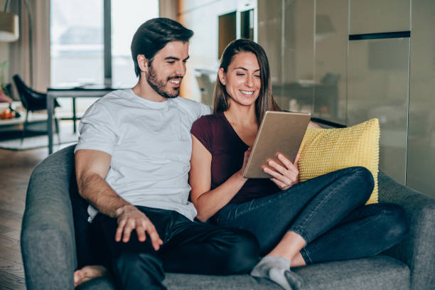 istock Smiling young couple using digital tablet at home. 1276701147