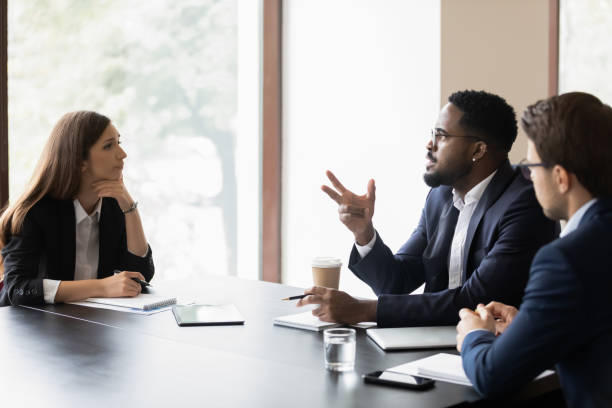 istock Multiethnic colleagues talk cooperate at team meeting 1276706750