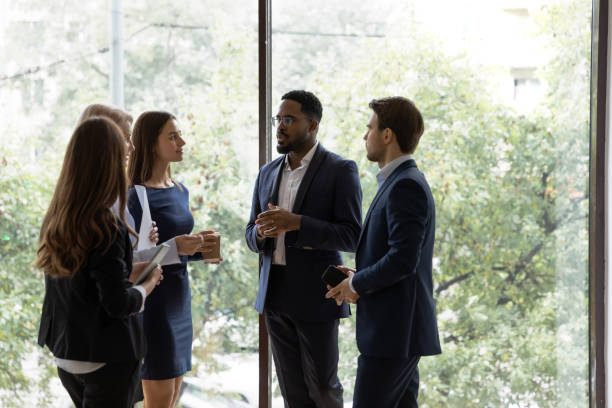 istock Multiethnic colleagues talk brainstorm in office hallway 1276706796