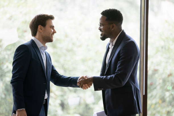 istock Smiling diverse businessmen handshake closing deal in office 1276706801