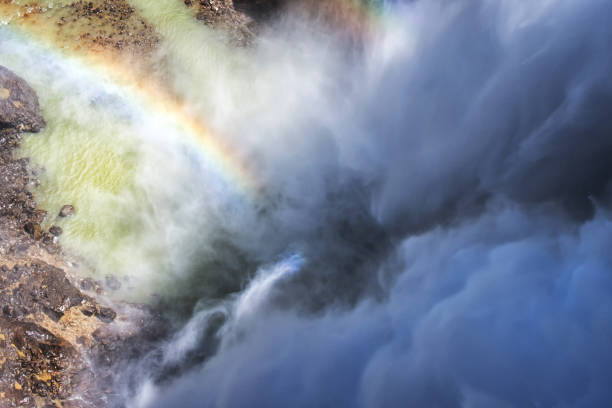 (Selective focus) Close-up view of the Tumpak Sewu Waterfalls with a beautiful rainbow formed by refraction of light in water droplets. Tumpak Sewu are waterfalls in East Java, Indonesia.