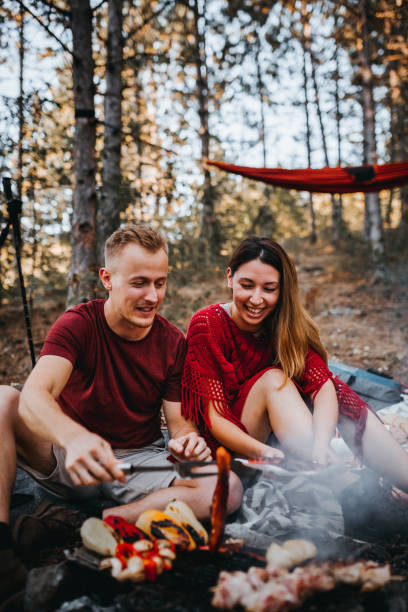istock Couple preparing a food in nature, campfire 1276716329
