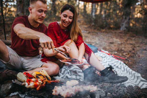 couples préparant une nourriture dans la nature, feu de camp - norwegian flag norway flag freedom photos et images de collection