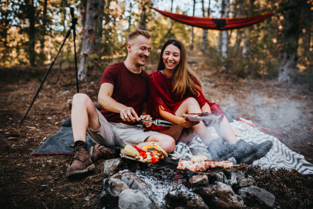 istock Couple preparing a food in nature, campfire 1276716934