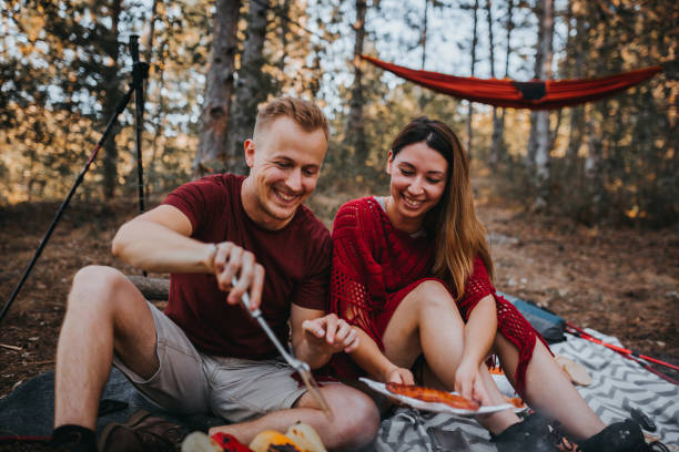istock Couple preparing a food in nature, campfire 1276717122