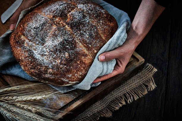 istock Woman's hands holding a freshly baked rustic bread 1276719759