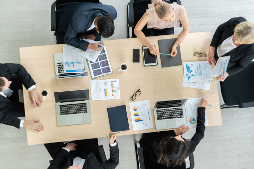 Business people group meeting shot from top view in office . Profession businesswomen, businessmen and office workers working in team conference with project planning document on meeting table .