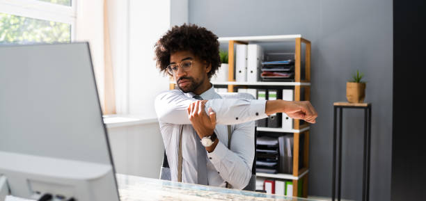 istock Black Man Stretching At Office Desk 1276730871