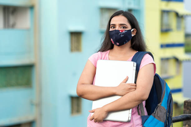 istock College or university student wearing protective face mask in a campus 1276731810