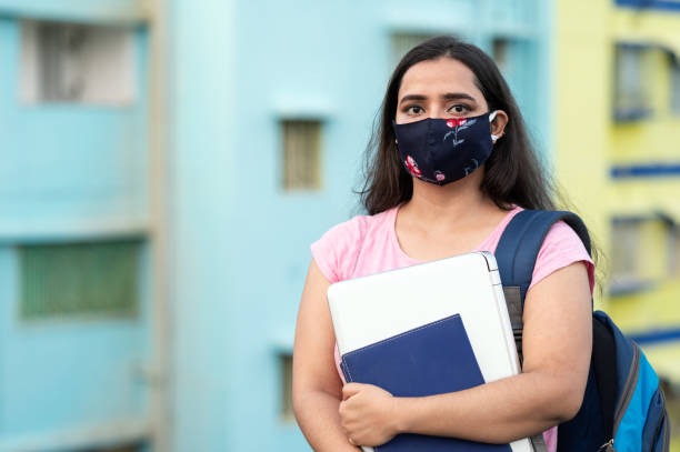 istock College or university student wearing protective face mask in a campus 1276731814
