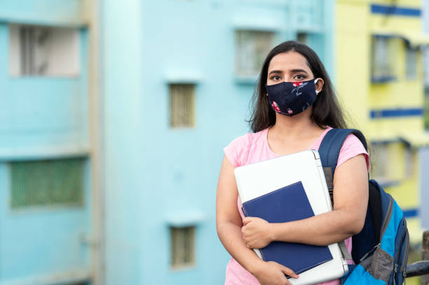 istock College or university student wearing protective face mask in a campus 1276731822