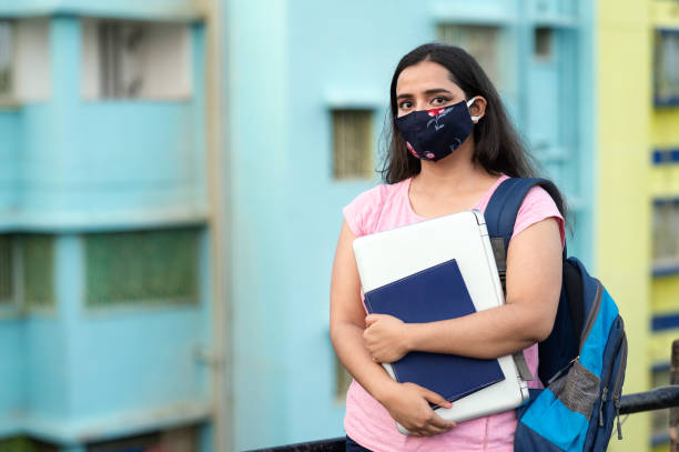 istock College or university student wearing protective face mask in a campus 1276731831