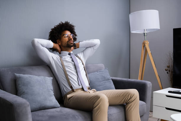 istock Young Man Sitting On Couch Relaxing 1276732011